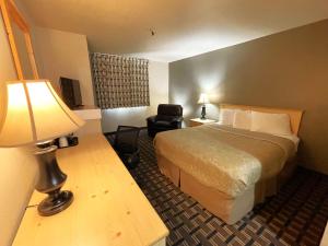 a hotel room with a bed and a chair at FairBridge Inn - Coeur d'Alene in Coeur d'Alene