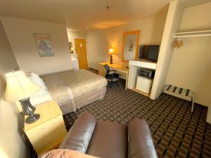 a hotel room with a bed and a couch at FairBridge Inn - Coeur d'Alene in Coeur d'Alene