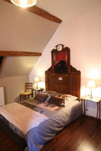 1 dormitorio con 1 cama grande con reloj en Chambre d'Hôtes du Domaine de la Haute Poignandiere, en Saint-Germain-de-la-Coudre