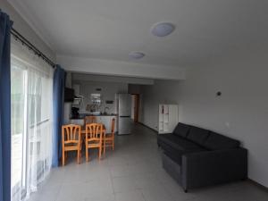 sala de estar con sofá negro y cocina en Apartamentos Praia do Almoxarife en Horta
