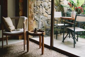 a room with chairs and a table and a mirror at Casa Salga in Ilhabela