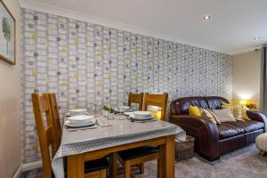 Percy House Cosy 2 Bedroom Home, Private Garden FREE PARKING Long Stays welcome في نوتينغهام: غرفة طعام مع طاولة وأريكة