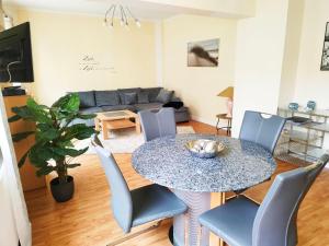 - un salon avec une table, des chaises et un canapé dans l'établissement Ferienhaus-Kassiopeia, à Laboe