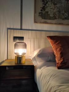 een lamp op een tafel naast een bed bij Apartamentos WUR in Madrid