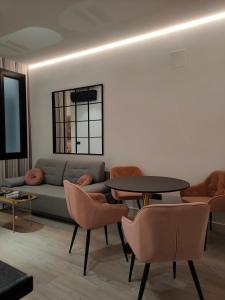 salon z kanapą, stołami i krzesłami w obiekcie Apartamentos WUR w Madrycie