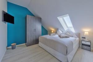 um quarto com uma cama grande e uma parede azul em Duenenrast in der Seefahrtschule em Wustrow