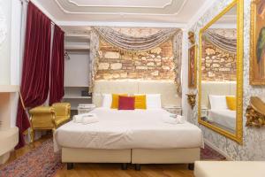 a bedroom with a large bed and a mirror at Royal Giardini dell'Arena Relais - Royal Welcome in Verona