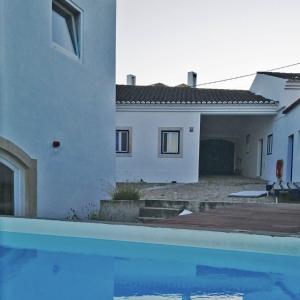 una casa e una piscina di fronte a una casa di Azóia 10 - Hostel & Casas de Campo a Azoia de Baixo