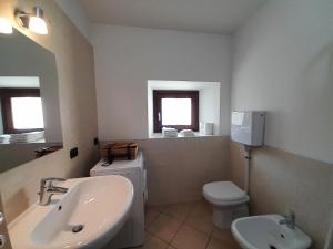 Baño blanco con lavabo y aseo en IL RUSTICO appartamento vacanze, en Tresivio