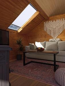 a living room with a couch and a skylight at Cottage Toladi in Kazbegi