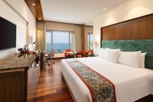 a hotel room with a bed and a desk at Welcomhotel by ITC Hotels, Devee Grand Bay, Visakhapatnam in Visakhapatnam