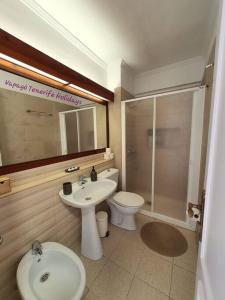 y baño con lavabo, aseo y ducha. en Lovely apartment in Costa Adeje, en Playa Fañabe
