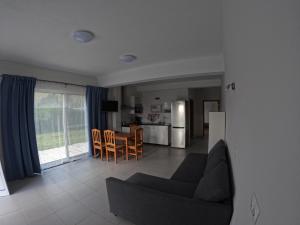 オルタにあるApartamentos Praia do Almoxarifeのリビングルーム(ソファ、テーブル付)、キッチンが備わります。