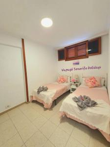 Habitación con 3 camas en una habitación en Lovely apartment in Costa Adeje, en Playa Fañabe