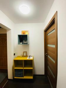une chambre avec une table jaune et une porte dans l'établissement Aparthotel City Center Targu Ocna, à Tîrgu Ocna