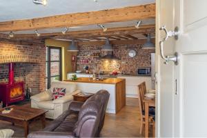 sala de estar con sofá y cocina en Wonderful wooden beamed 17th century retreat - White Lion Cottage, en Hadleigh