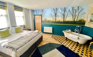 sypialnia z łóżkiem, wanną i oknem w obiekcie Helen Browning's Royal Oak w mieście Swindon