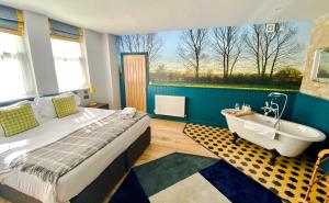 a bedroom with a bed and a tub and a window at Helen Browning's Royal Oak in Swindon