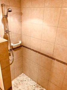 eine Duschkabine im Bad mit Fliesenboden in der Unterkunft Gîte de l’écuyer in Eygurande-et-Gardedeuil