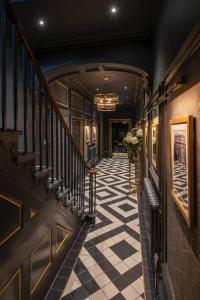 a hallway with a staircase with a checkered floor at Edgbaston House in Birmingham
