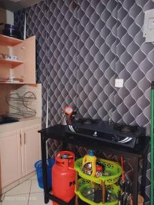uma cozinha com uma parede de azulejos pretos em Monique Furnished Studio apartment -South B em Nairobi