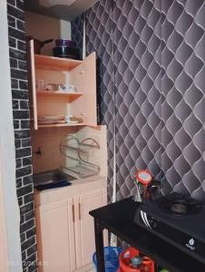 uma pequena cozinha com uma parede de azulejos pretos e cinzentos em Monique Furnished Studio apartment -South B em Nairobi