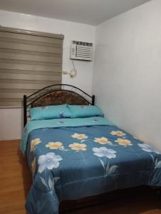Schlafzimmer mit einem Bett mit blauer Decke in der Unterkunft Drea Staycation 2 Bedroom at Urban Deca Homes Marilao in Marilao
