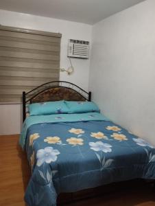 een slaapkamer met een bed met een blauw dekbed bij Drea Staycation 2 Bedroom at Urban Deca Homes Marilao in Marilao