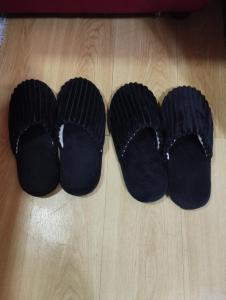 a group of black slippers on a wooden floor at Drea Staycation 2 Bedroom at Urban Deca Homes Marilao in Marilao