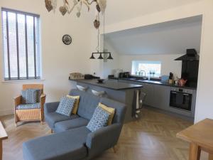 a living room with a couch and a kitchen at Old Schoolhouse in Lairg