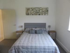 a bedroom with a bed with a plaid blanket at Old Schoolhouse in Lairg