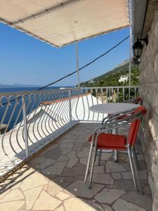 een tafel en stoelen op een balkon met uitzicht op de oceaan bij Apartments Leut in Pisak