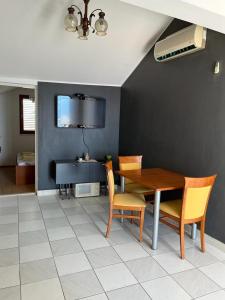 uma sala de jantar com mesa e cadeiras e uma televisão em Apartments Leut em Pisak