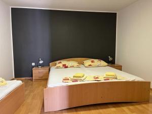 een slaapkamer met een groot bed en een zwarte muur bij Apartments Leut in Pisak