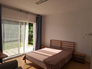 オルタにあるApartamentos Praia do Almoxarifeのベッドルーム1室(ベッド1台、大きな窓付)