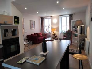 Les Chambres Hautes d'Anastasia في روديه: مطبخ وغرفة معيشة مع أريكة حمراء