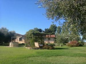una casa in un cortile con un campo verde di Casale Dinelli a Tarquinia