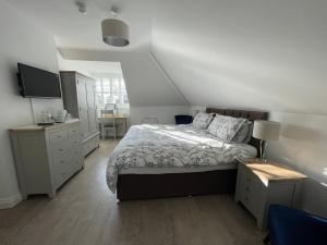 1 dormitorio con cama, escritorio y lavamanos en Cotswold Hare en Cirencester