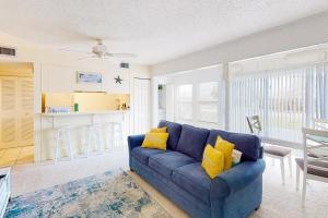 Sofá azul en la sala de estar con almohadas amarillas en Gulf Terrace 126 en Destin