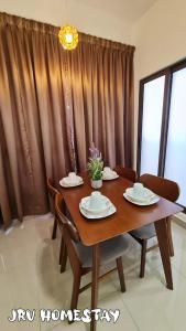 una mesa de comedor de madera con sillas y un comedor en JRv HotelStyle HomeStay Melaka, en Melaka