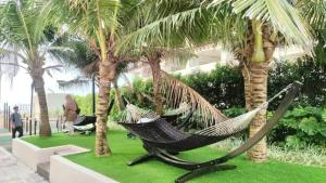 a hammock in a garden with palm trees at JRv HotelStyle HomeStay Melaka in Melaka