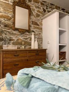 ein Schlafzimmer mit einer Kommode und einem Spiegel in der Unterkunft Casa Da Oliveira in Pedrógão Grande