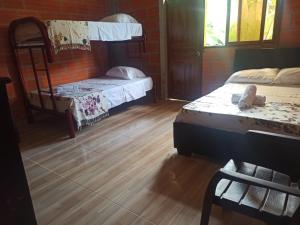 um quarto com 2 beliches e piso em madeira em Reserva Ecoturística Villa Diosa em Confines