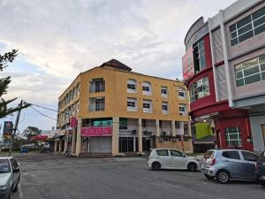 Mi Hotel 2 Dungun في دونجون: شارع فيه سيارات تقف امام مبنى