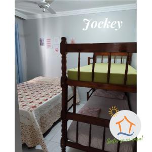 een slaapkamer met 2 stapelbedden en een bord met Tobey bij Ap Privativo Jockey, uma quadra da praia, Sentir-se em casa! in Vila Velha