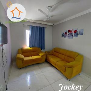 uma sala de estar com duas cadeiras e um sofá em Ap Privativo Jockey, uma quadra da praia, Sentir-se em casa! em Vila Velha