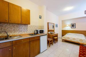 a kitchen with a sink and a bed in a room at Summer Memories Aparthotel in Pefki Rhodes