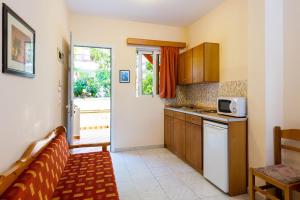 a small kitchen with a couch and a microwave at Summer Memories Aparthotel in Pefki Rhodes