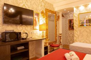 a bedroom with a bed and a tv on a wall at Giardini dell'Arena Relais in Verona