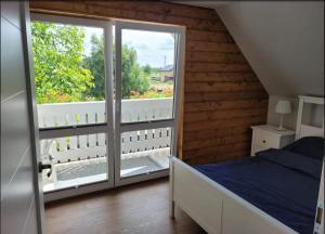 a bedroom with a bed and a large window at DOMEK W TRZĘSACZU in Trzęsacz